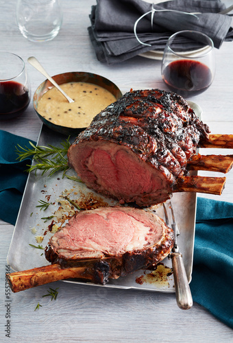 Standing rib roast with bearnaise sauce and glasses of red wine photo