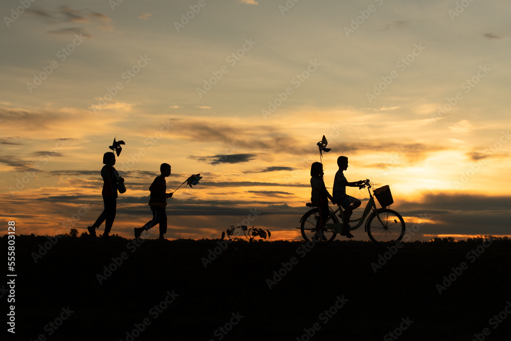 Children riding bicycles and running In the early light of the day as the sun shines