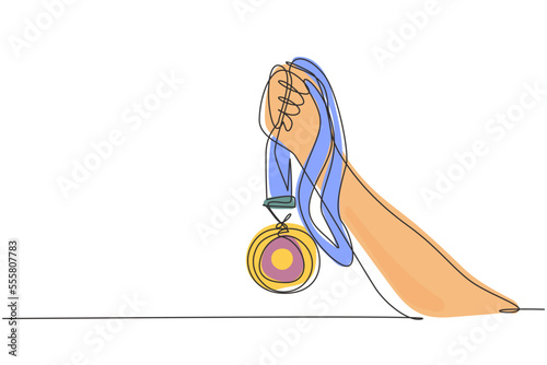 Single one line drawing gold medal held by one hand. Symbol of winning championships, matches and sports competitions. Best achievement ever. Continuous line draw design graphic vector illustration