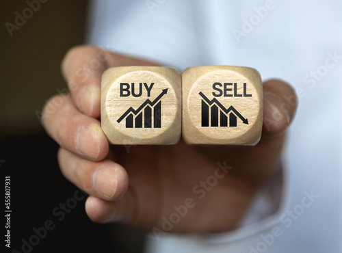 Dices cubes with the words SELL BUY on financial downtrend chart graph. Selective focus