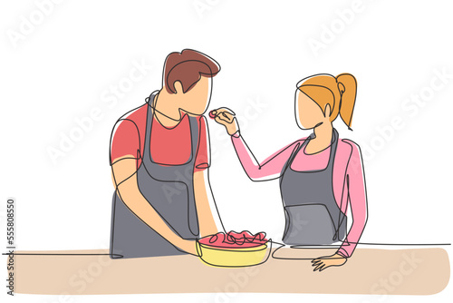 Continuous one line drawing beautiful wife feeds her husband food and in front of him is bowl filled with salad. Cooking together in cozy kitchen. Single line draw design vector graphic illustration