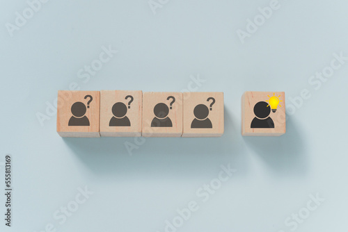 Problem solving, creative idea or innovative idea, outstanding person concept. outstanding wooden blocks with brighten lightbulb icon with blurred others and question mark