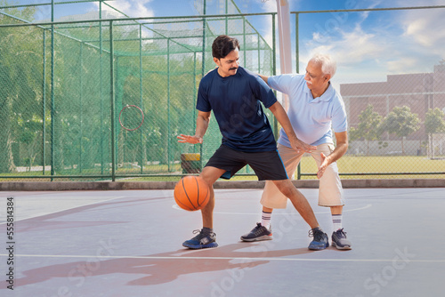 Father and son playing basketball. © G-images