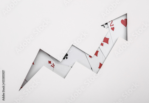 Growth arrow from cut paper with playing cards. Gambling concept