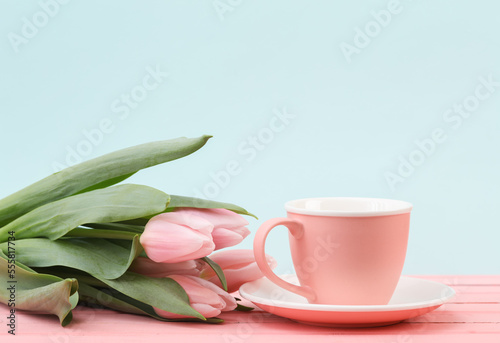Ceramic cup with tulips on a pastel background