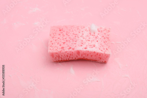 Sponge with foam on a pink background. Cleaning concept