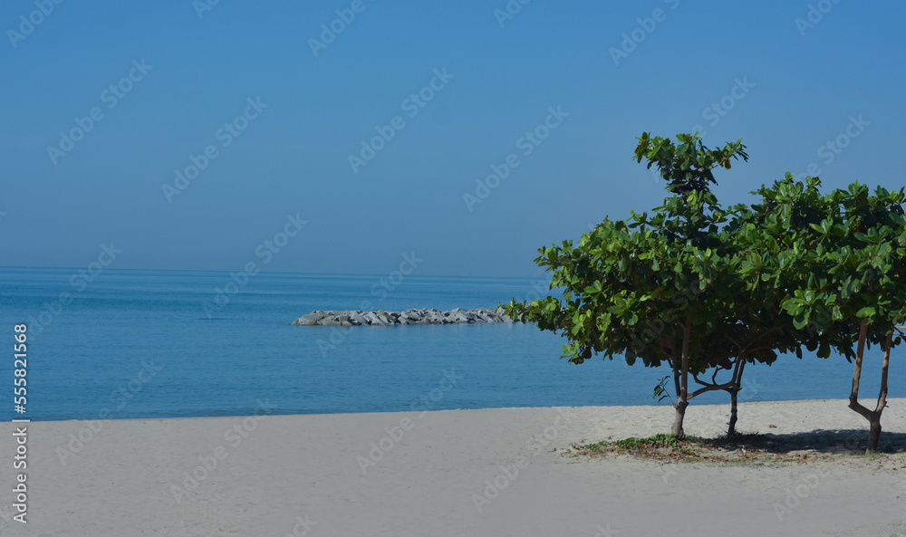 At the seashore, there is blue water and rocks. sea breeze sand