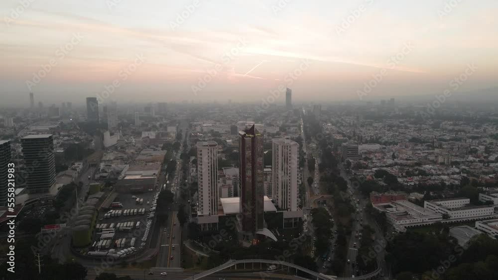 Aerial wide shot towards of the Hard Rock with a majestic orange sky in background over Guadalajara, Jalisco, Mexico. Aerial wide shot towards of the Hard Rock with a majestic orange sky in background over Guadalajara, Jalisco, Mexico.