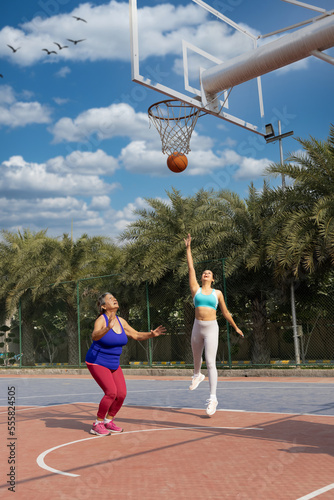 Mother and daughter playing basketball. © G-images