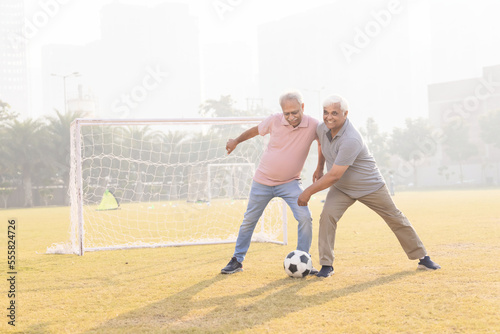 Photography Senior friends playing football together.