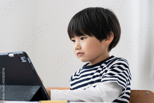 タブレットPCを見る日本人小学生の男の子