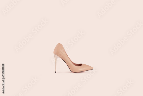 Beautiful beige leather female fashion high heel shoes isolated on light beige background