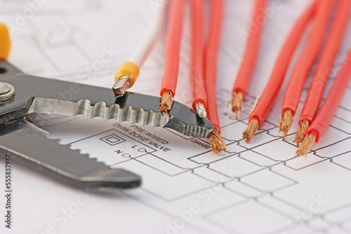 Tools for the installation of an electrical switchboard and insulated copper wires. On the electrical diagram close-up.