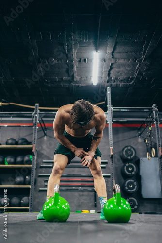 Vertical photo of a tired man training in a gym