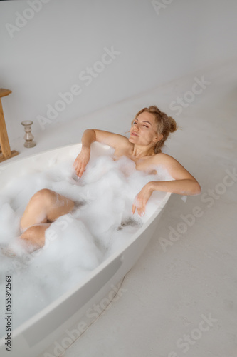 Overhead view on woman relaxing in bath with soap foam