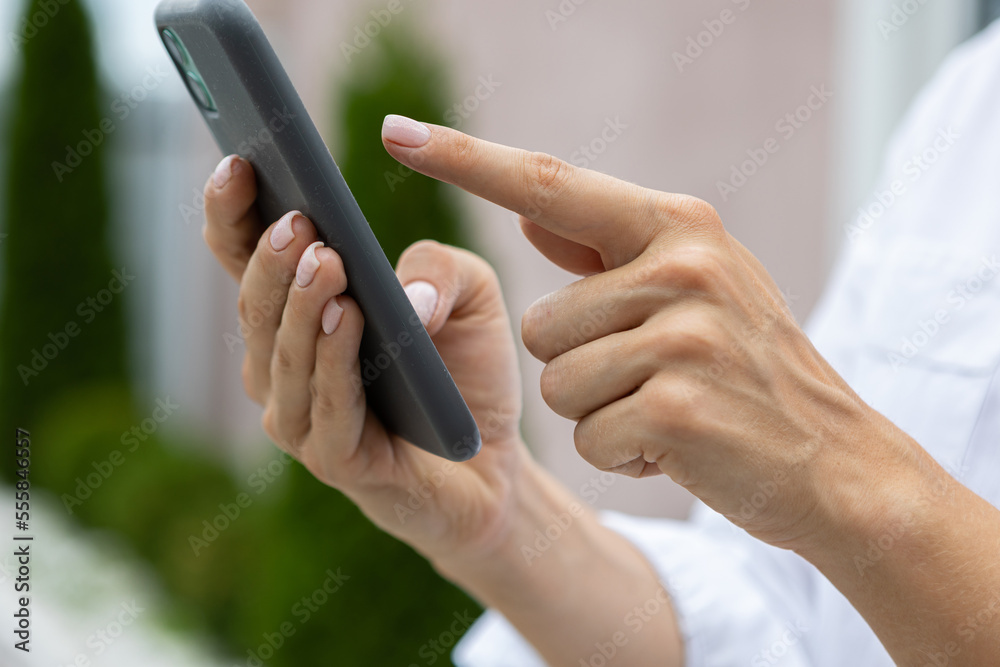 female hands hold a modern mobile phone on the street..education, modern app, shopping order, work online