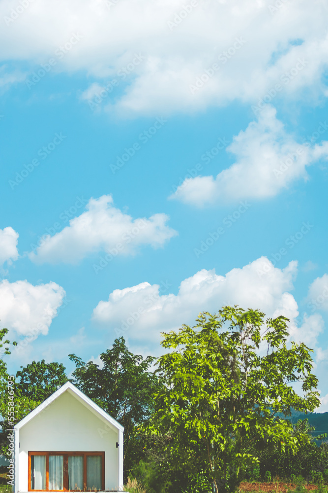 Small beautiful resort building with tree and blue sky and white clouds.