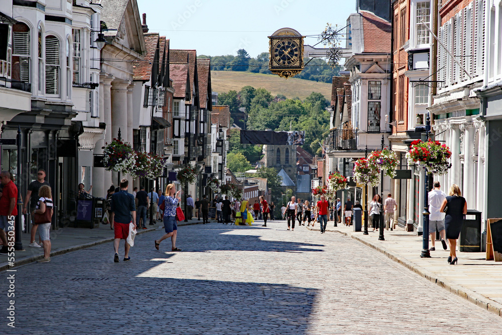Fototapeta premium Guildford’s cobbled high street bustling with anonymised shops and shoppers