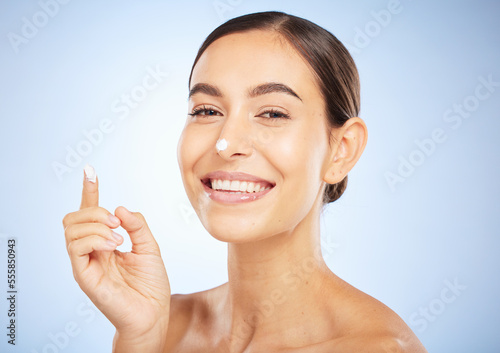 Portrait, skincare and moisturizer with a model woman in studio on a gray background for antiaging beauty. Face, lotion and product with an attractive young female inside to apply facial treatment