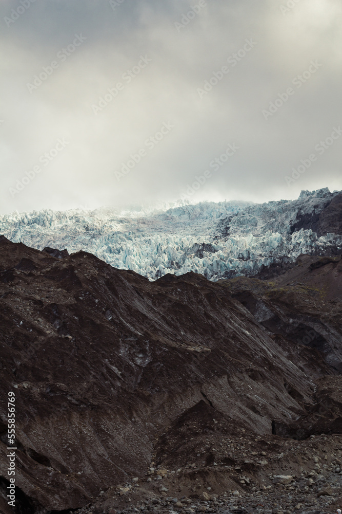 Steep cliffs covered with snow landscape photo. Beautiful nature scenery photography with grey sky on background. Idyllic scene. High quality picture for wallpaper, travel blog, magazine, article
