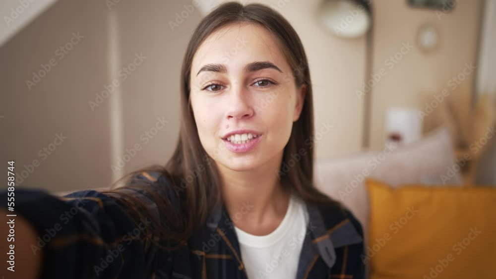 Smiling young caucasian woman vlogger make video call, looking at camera, recording vlog at home, talking. View from front camera to portrait video recording, girl holds mobile phone in hands. Smiling young caucasian woman vlogger make video call, looking at camera, recording vlog at home, talking. View from front camera to portrait video recording, girl holds mobile phone in hands.