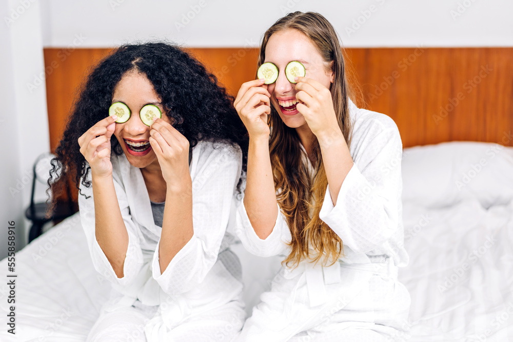 Portrait of smiling of happy beauty woman friend clean fresh healthy white skin spa treatment.african girl mask face with cucumber facial mask in the room.beauty and spa.perfect fresh skin Portrait of smiling of happy beauty woman friend clean fresh healthy white skin spa treatment.african girl mask face with cucumber facial mask in the room.beauty and spa.perfect fresh skin