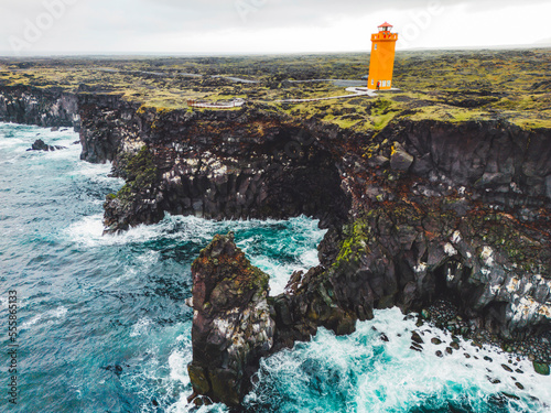 Orange Svortuloft Lighthouse and stormy sea down bellow photo