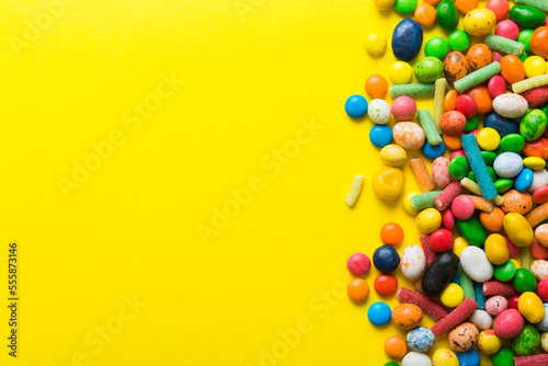 Mixed collection of colorful candy, on colored background. Flat lay, top view. frame of colorful chocolate coated candy