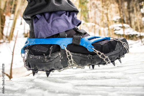 Crampons on hiking boot. Hiking in winter. Frozen hiking trail