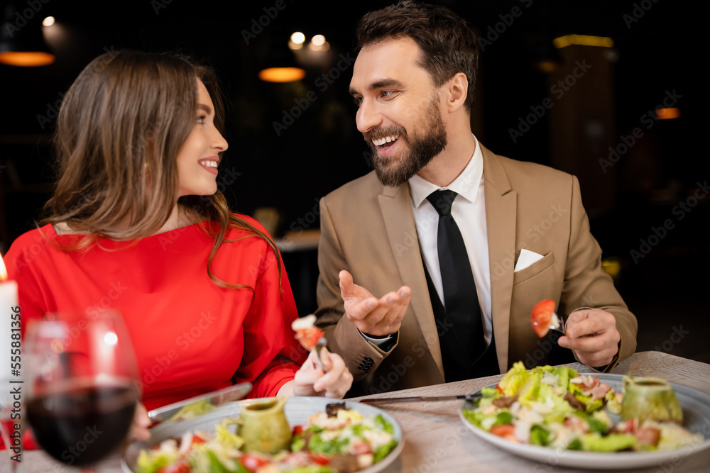 smiling young couple in festive attire talking during celebration on valentines day smiling young couple in festive attire talking during celebration on valentines day