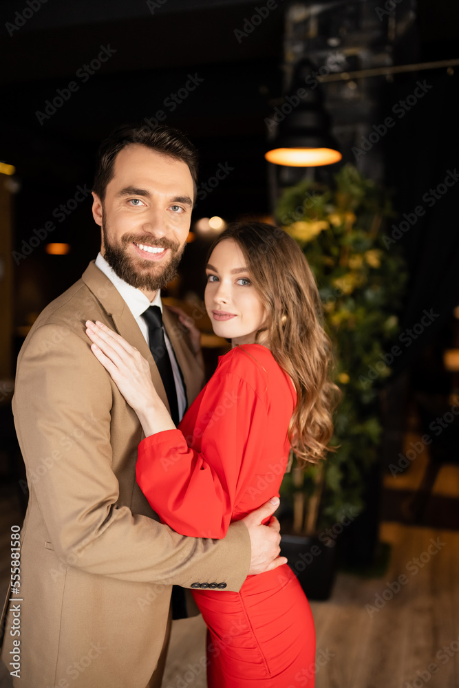 smiling man and woman in festive attire hugging each other on valentines day smiling man and woman in festive attire hugging each other on valentines day