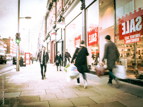 Motion blurred shoppers on busy street
