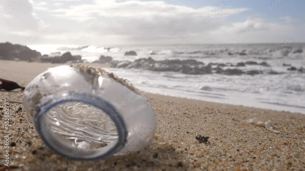 Plastic bottle garbage lying on Atlantic ocean sand beach in Portugal - environment nature pollution
