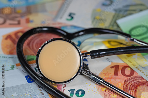 Stethoskop auf Geldscheinen symbolisch für Gesundheitskosten photo