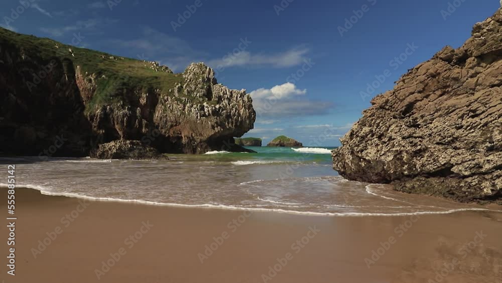 Beautiful small beach without people in the north of Spain in summer. A wave approaching the camera on the shore of the beach. Beautiful small beach without people in the north of Spain in summer. A wave approaching the camera on the shore of the beach.