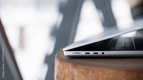 magsafe 3. Macbook pro 14 2021. magnetic charger charges laptop on wood background. USB-C to MagSafe 3 Cable 