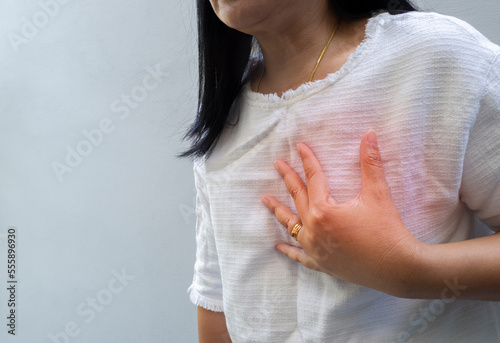 Woman touching chest. Heart attack, heart disease, and chest pain concepts