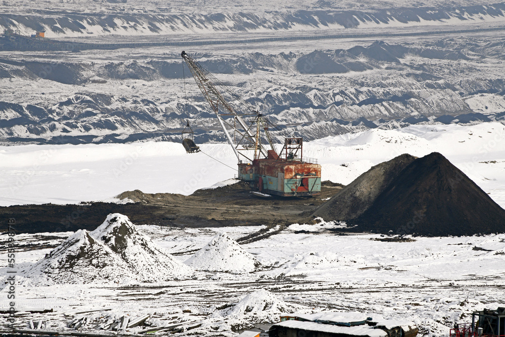 A huge excavator on a surface coal mine in winter conditions. Interesting appearance of surface mining under snow. A huge excavator on a surface coal mine in winter conditions. Interesting appearance of surface mining under snow.