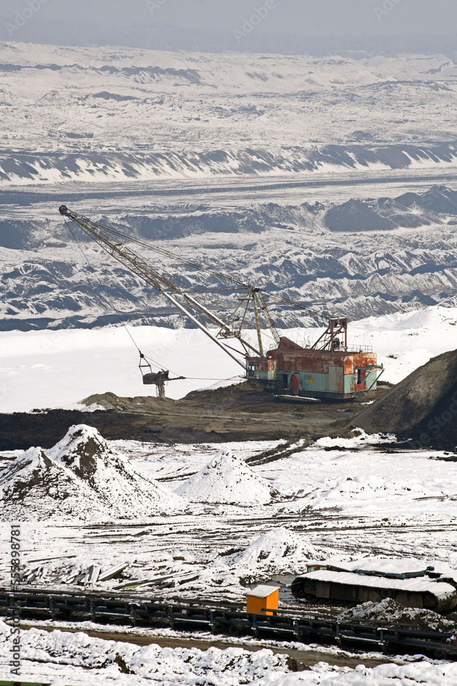 A huge excavator on a surface coal mine in winter conditions. Interesting appearance of surface mining under snow.