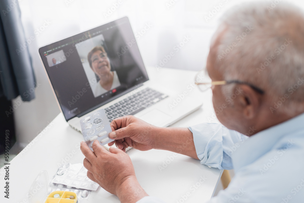 Telemedicine concept, senior asian man using laptop video call with nurse, consulting taking pills. At home.