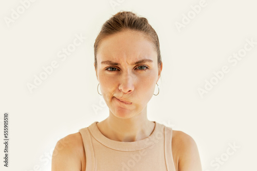 Angry frustrated female trying to keep calm curving and pursing her lips tightly, mad at her husband, frowning looking at camera. Negative human emotions, facial expression, body language