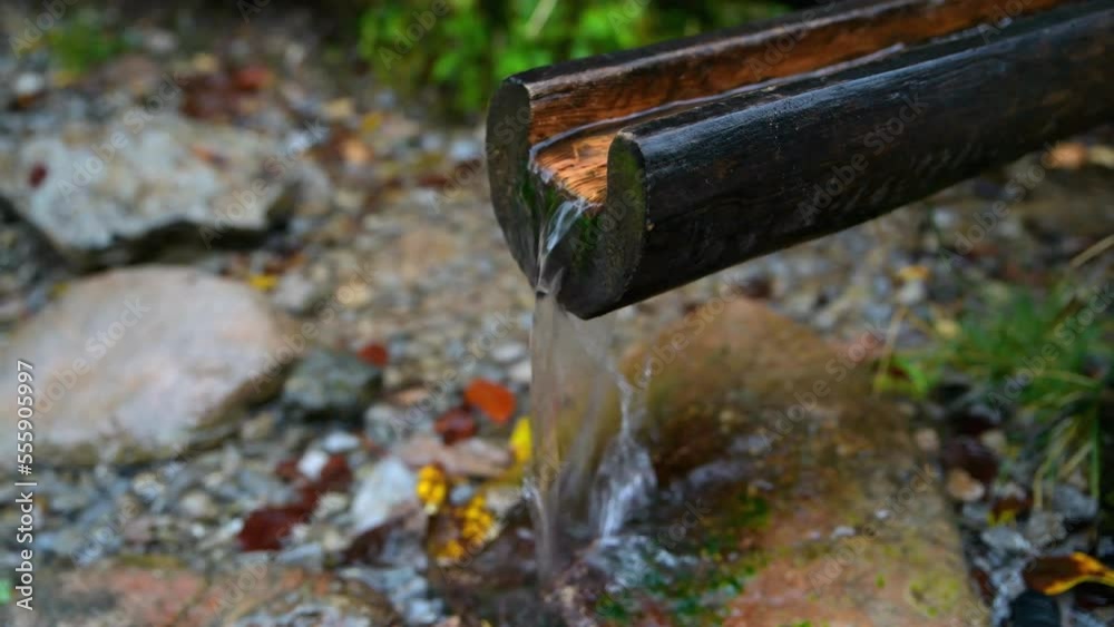 clean water flowing from a wooden gutter on a tourist trail clean water flowing from a wooden gutter on a tourist trail