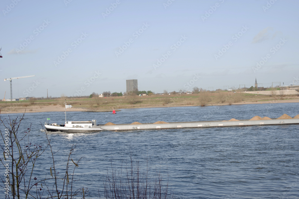 Obraz premium Cargo hold of a cargo ship carrying heaps of sand in a river