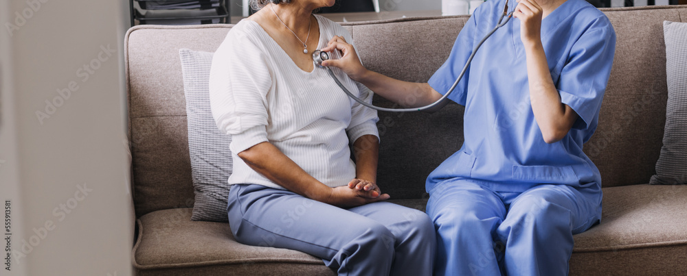 Obraz premium Homecare nursing service and elderly people cardiology healthcare. Close up of young hispanic female doctor nurse check mature caucasian man patient heartbeat using stethoscope during visit