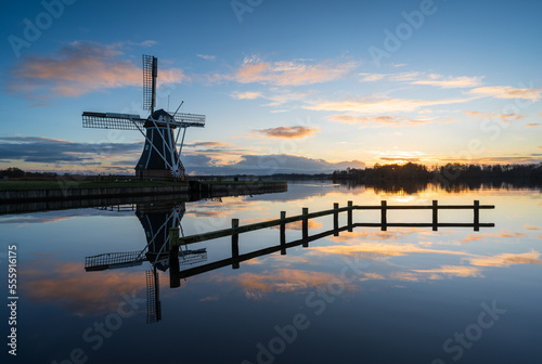 Traditional Dutch windmill during a tranquil and sunset in winter.