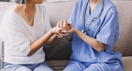 Homecare nursing service and elderly people cardiology healthcare. Close up of young hispanic female doctor nurse check mature caucasian man patient heartbeat using stethoscope during visit