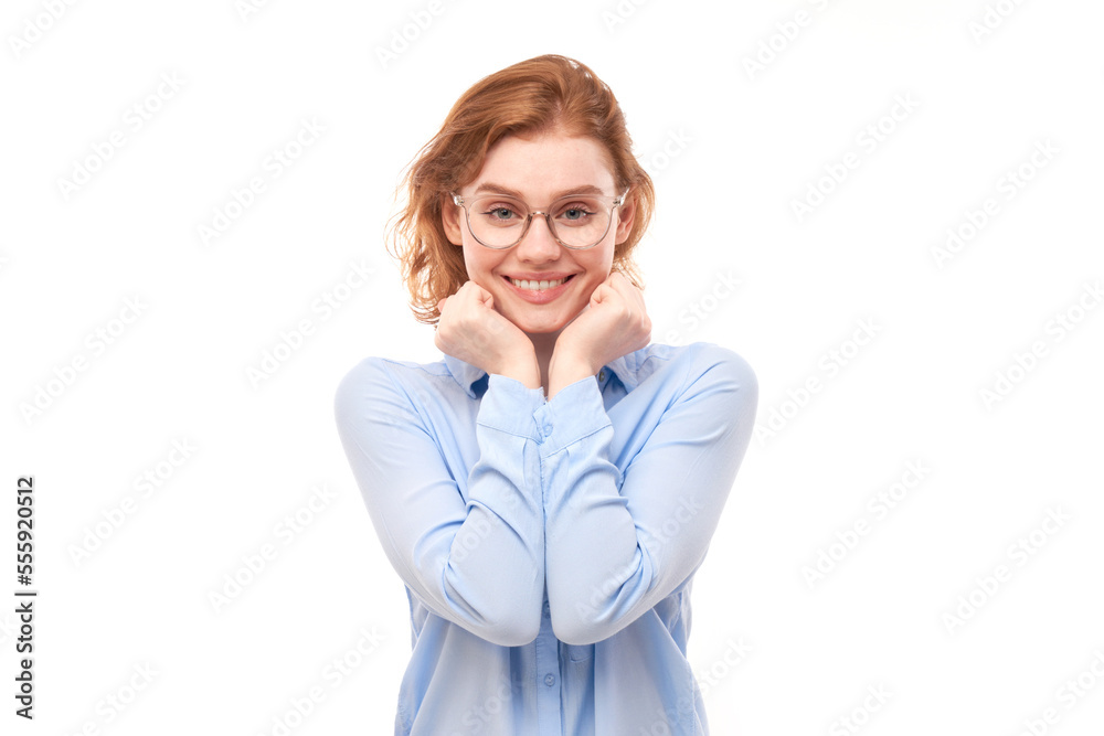 Portrait of attractive red-haired girl in business shirt and glasses smiling joyfully isolated on white studio background.
