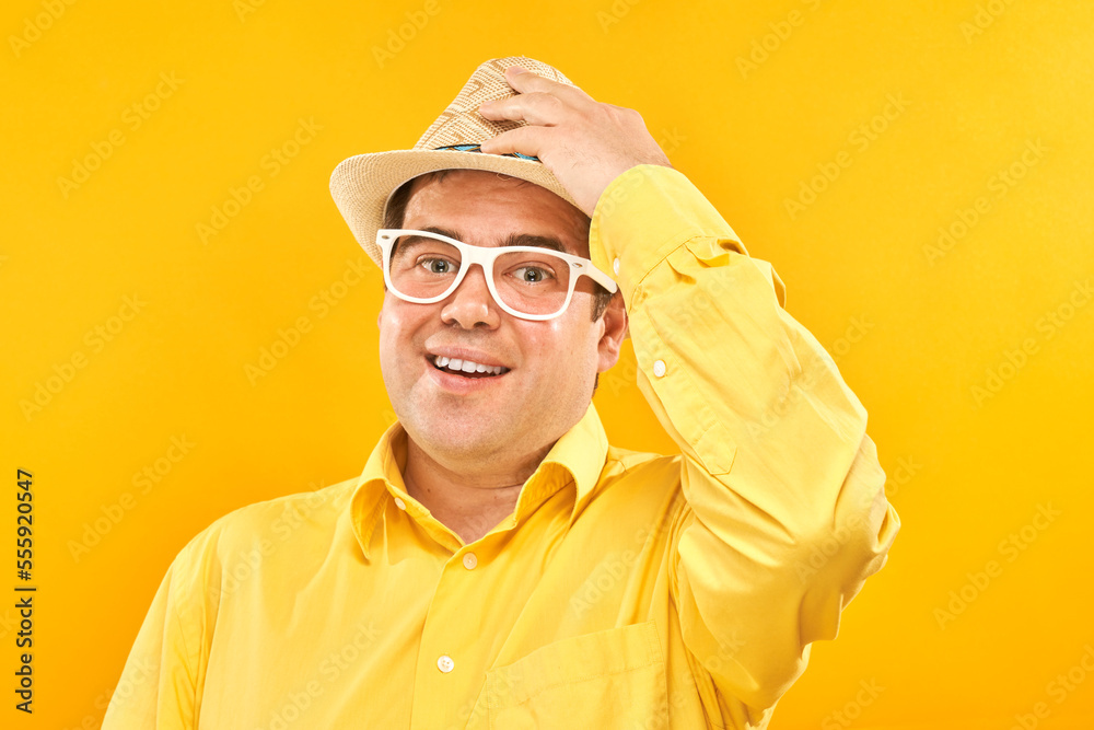 Portrait of positive fat man in hat kindly smiling isolated on yellow studio background, travel vacation concept Portrait of positive fat man in hat kindly smiling isolated on yellow studio background, travel vacation concept