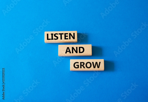 Listen and grow symbol. Concept words Listen and grow on wooden blocks. Beautiful blue background. Business and Listen and grow concept. Copy space.