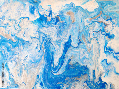 liquid acrylic fluid art close up.  Blue liquid marble effect, modern fluid art. Blue and gold abstract painted background. Drawing Creative wallpaper, beautiful design. Waves effect, trendy wash draw